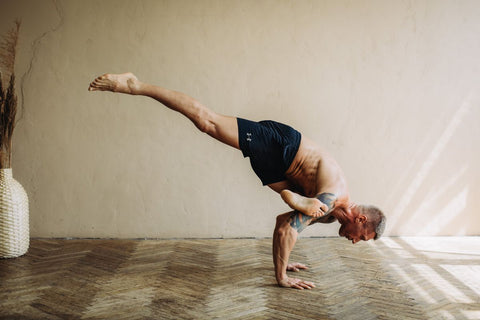 Man in a complex handstand yoga pose