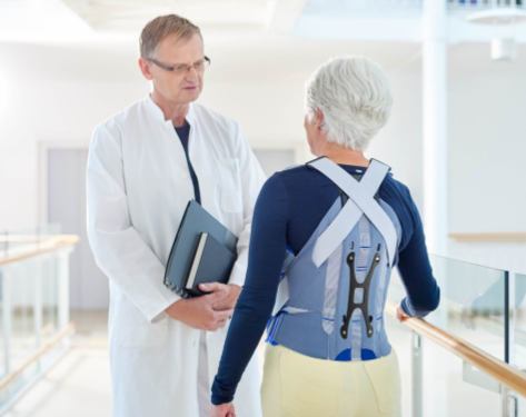 Patient portant un corset Bauerfeind parlant à un médecin