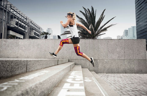 Woman running in sports knee braces, also a good way to prevent ITBS