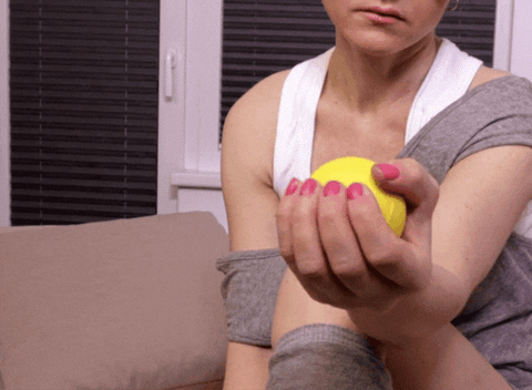 Woman squeezing a stress ball, a good way to relieve some symptoms wrist arthritis