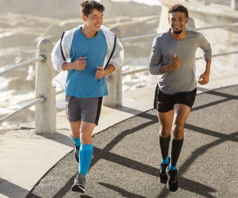 Two triathletes training for the run in Bauerfeind compression calf sleeves and socks