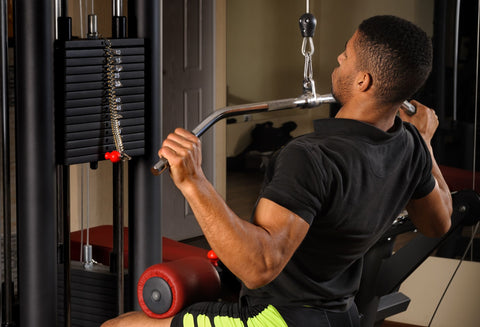 Man in the gym doing the lat pull down exercise. It's a great way to avoid and help relieve shoulder bursitis