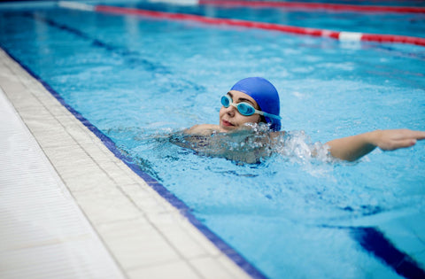 Woman practicing proper arm positioning in a pool, a good way to avoid swimmer's shoulder