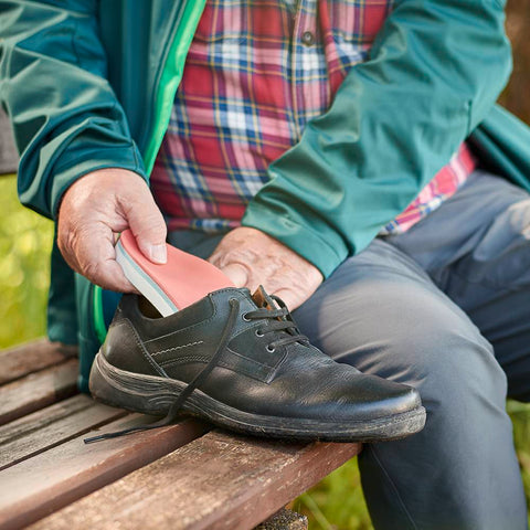 Personne insérant une semelle intérieure pour pied diabétique dans sa chaussure