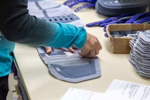 Bauerfeind employee assembling a LumboTrain back brace by hand.