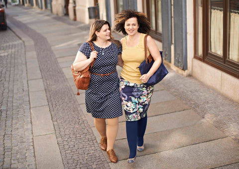 Two women wearing compression garments walking down the street