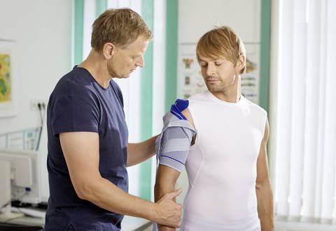 Male being fitted for the Bauerfiend OmoTrain shoulder brace by a specialist