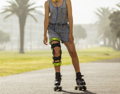Woman roller blading through the park while wearing Buaerfeind's SecuTec Genu Knee Brace