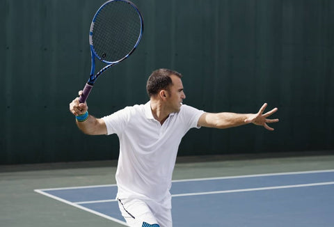Tannis player in the middle of making a forehand shot. He is wearing a Bauerfeind Wrist Strap to protect his wrist from injury