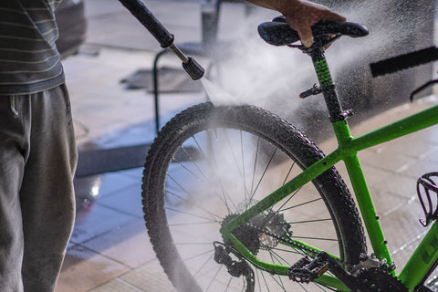 Man washing his bike to keep it well maintained - a good cycling tip for beginners