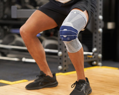 Man wearing a GenuTrain Knee Brace while doing squats at the gym
