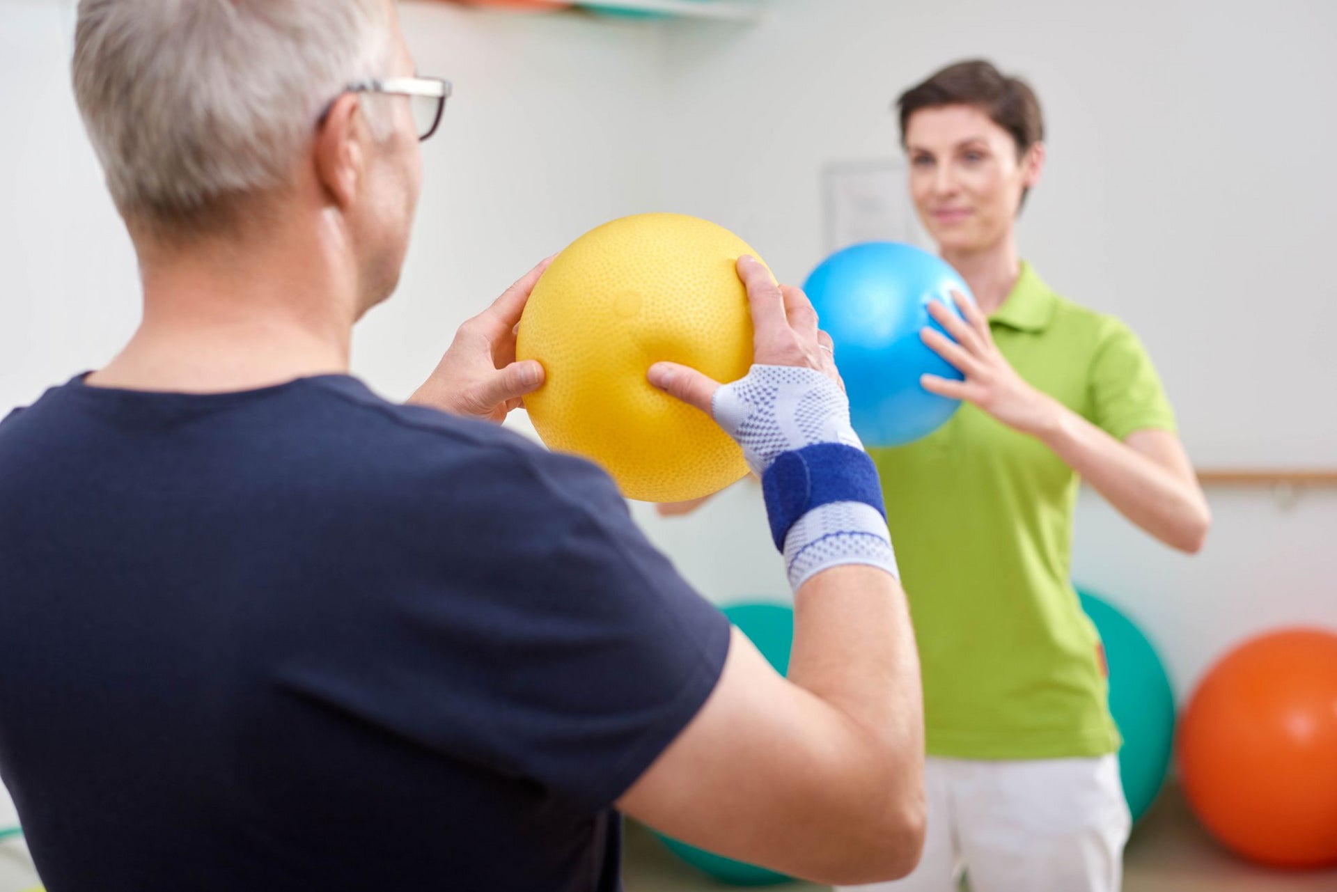 Patient working with physio doing wrist arthritis exercises