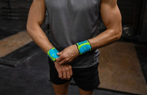 Man putting on Bauerfeind's Sports Wrist Strap before indoor rock climbing