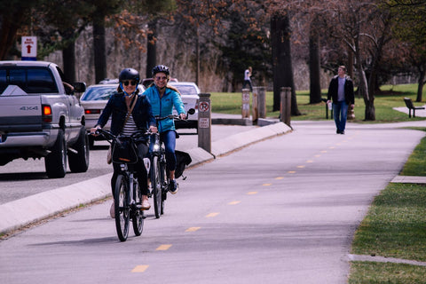 People cycling through a park with wide bike lanes, a good place for beginners to practice