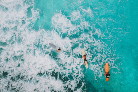 People surfing on turquoise waters with some gentle waves