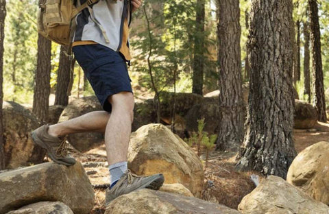 Man hiking in the woods in Bauerfeind's MalleoTrain Ankle Brace to relieve ankle pain