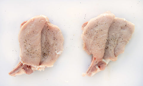 Image of two butterflied pork chops waiting to be 10derized.
