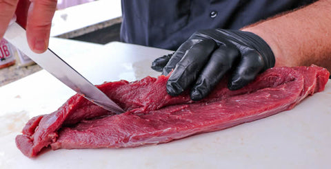 Image of cutting a slit down the middle of the backstrap to prep it for stuffing.