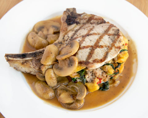 Image of plated stuffed pork chop with mushroom sauce.