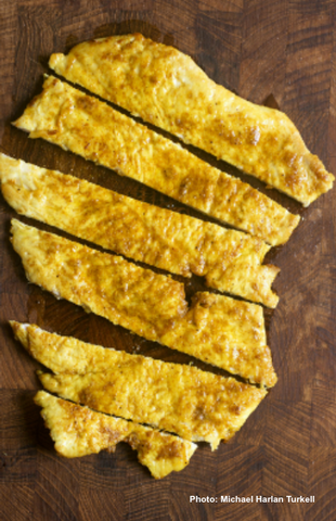 Image of a tender Indian chicken breast sliced on a cutting board