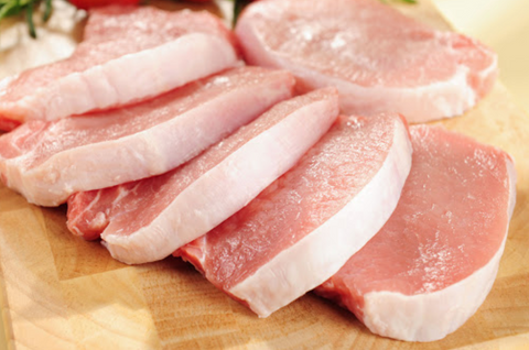 Image of 6 raw pork loin steaks on a cutting board.