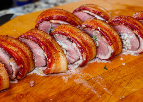 Image of fully-cooked stuffed backstrap sliced on cutting board.