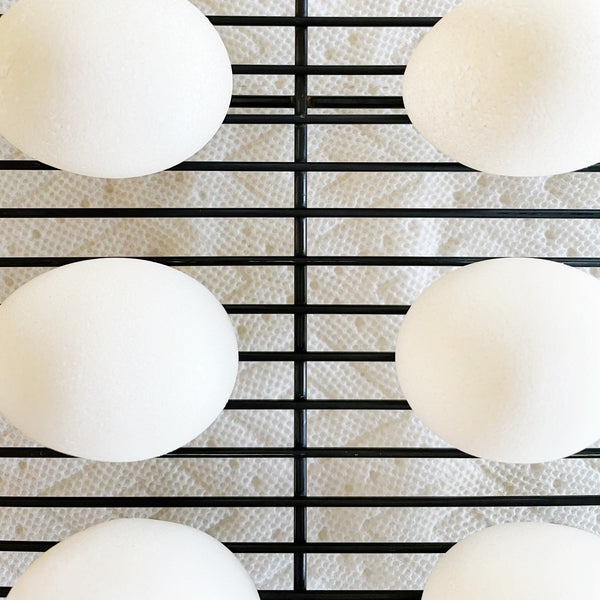 hard boiled eggs drying on a baking rack