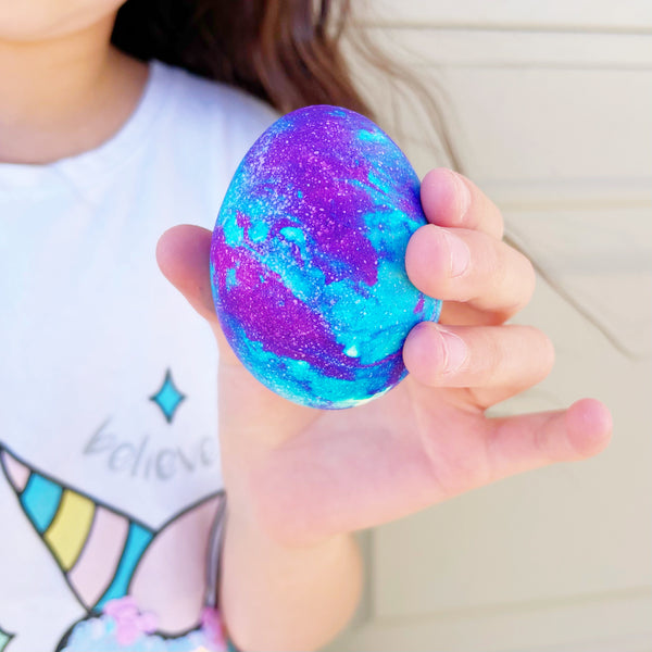 girl holding an Easter egg dyed with whipped cream