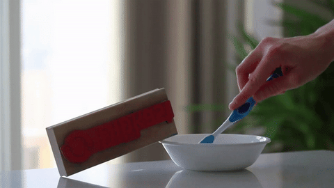 Create paste with distilled water and baking soda. Using a toothbrush, wash stamp with paste.