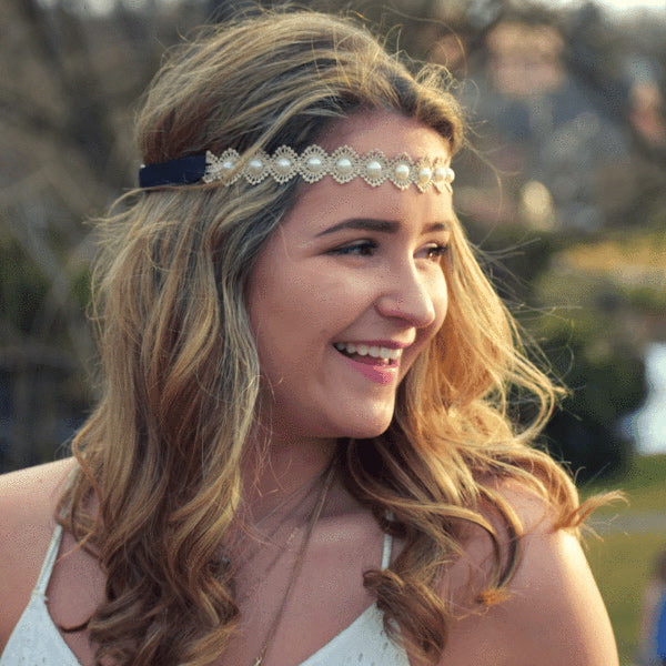 a woman wearing a pearl headband across her forehead