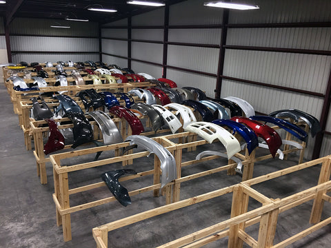 Prepainted bumpers drying on soft wooden dryin racks