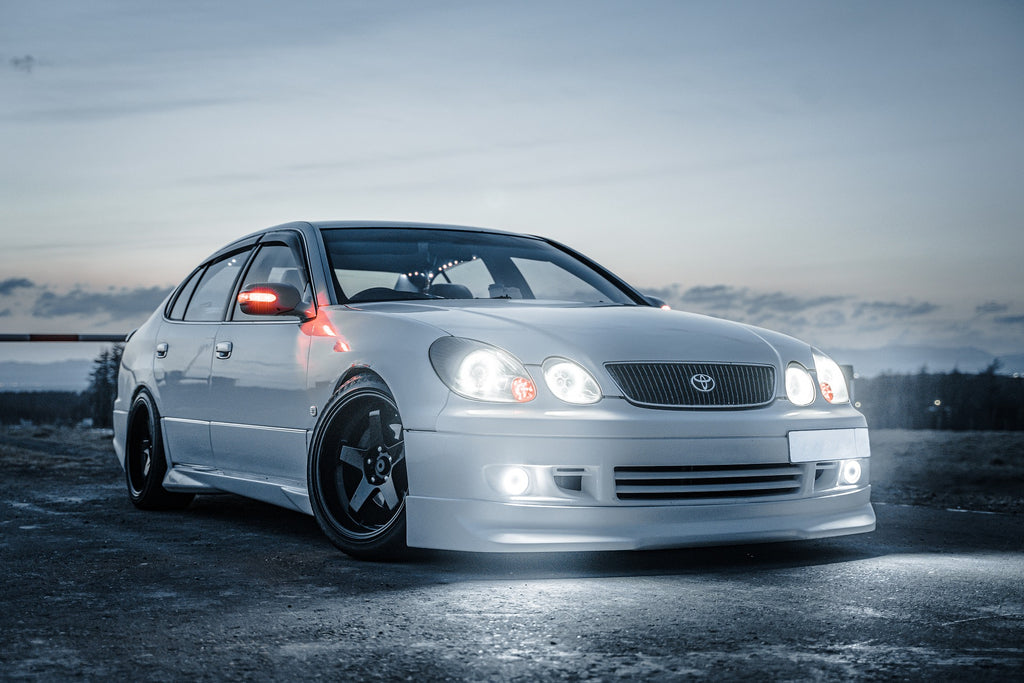 Silver Toyota Camry front view with lights on