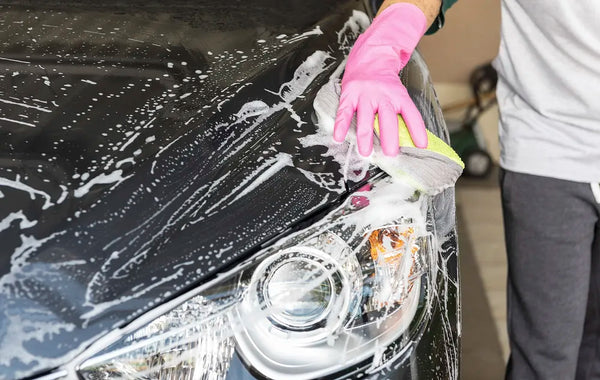 Washing a car with a pink glove