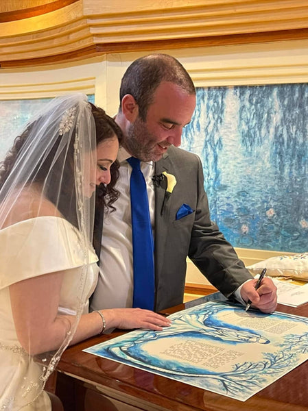 Another interreligious newlywed couple signing a secular or nondenominational ketubah!