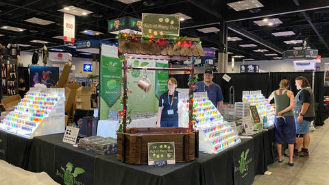 Booth is partially set up, with employees working amidst boxes and dice displays