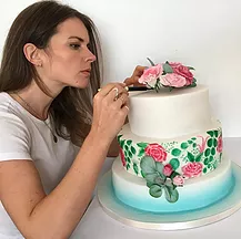 Lily decorating a two tier cake
