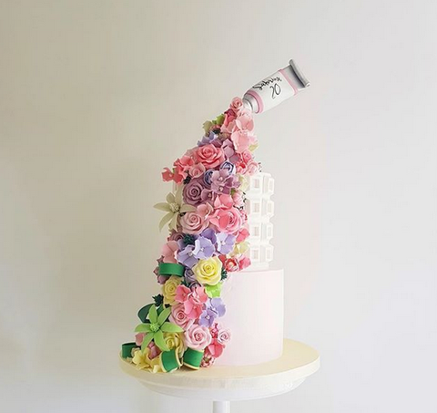 MY BAKER Top 25 Inspirational Baker Awards - @kekandco - A sweet tube pours an array of flowers onto a tiered cake