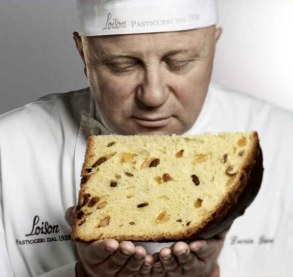 Dario loison holding a slice of rich classic Loison panettone