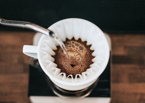 A person pouring water over coffee