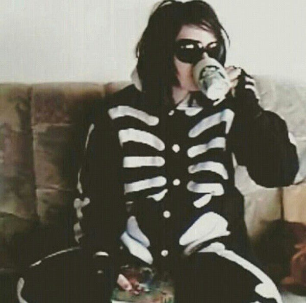 Gerard Way drinking a coffee with his full skeleton kigurumi