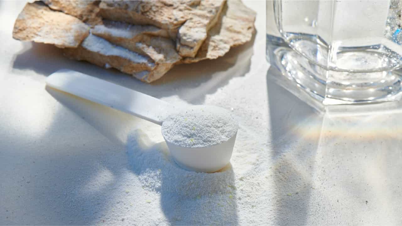 Scoop of magnesium next to a glass and bread slices