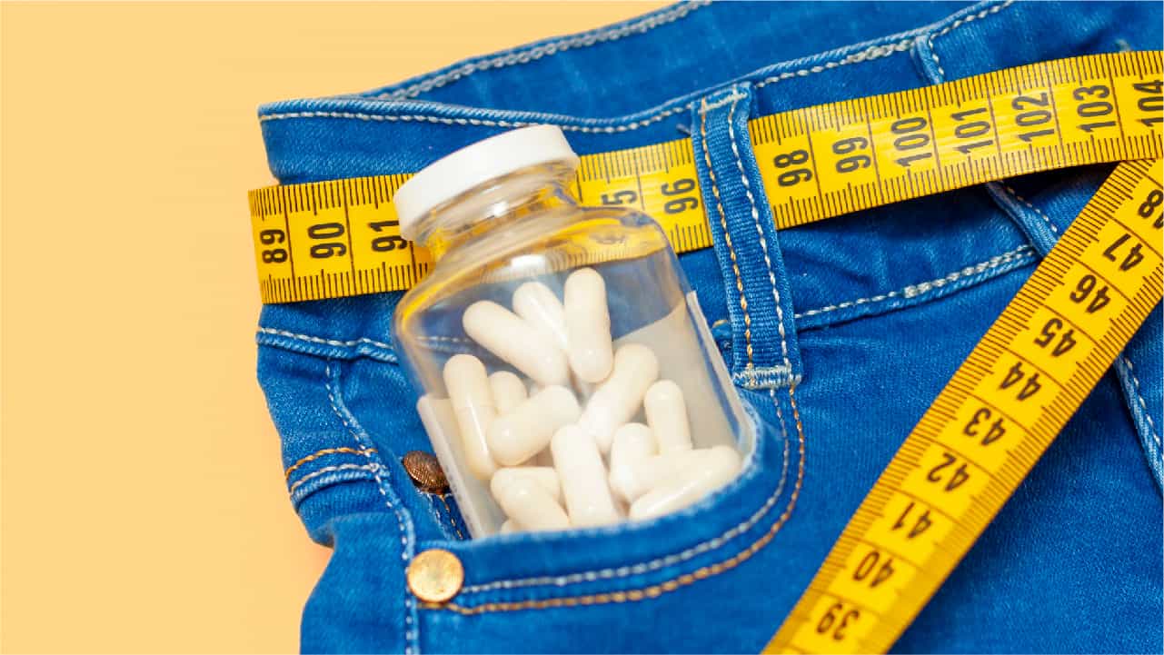 Bottle of magnesium supplement in the pocket of a blue pair of jeans with a tape measure as a belt. Conveying the message that magnesium may help you lose weight