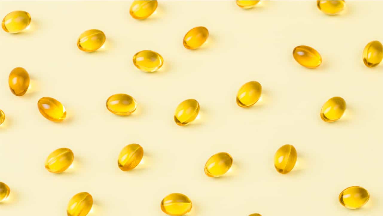 Capsules of 'fish oil' on a lemon yellow background