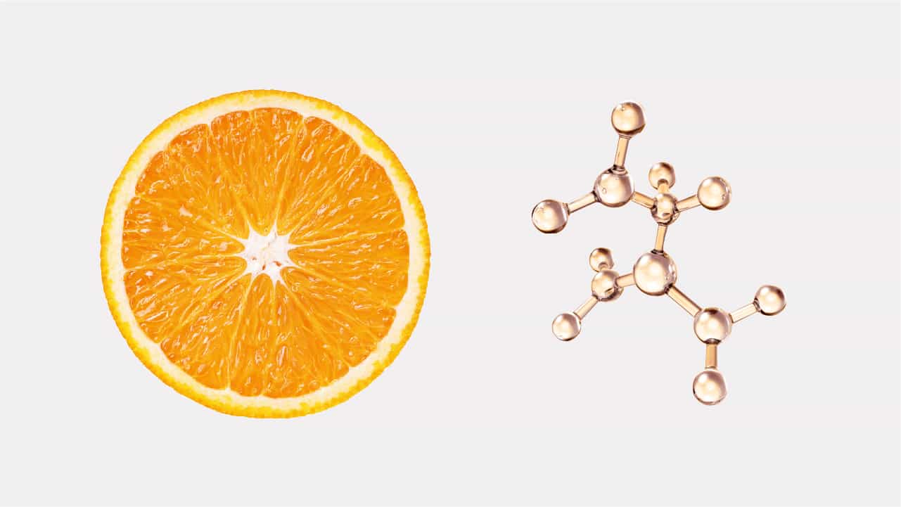 Vitamin C as NutriGenesis matches nature. A halved orange surrounded by golden nutrient chemical structure models against a pale background