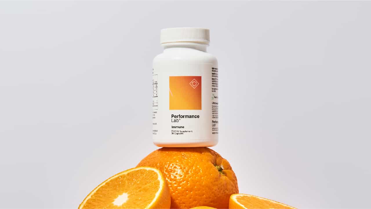 Performance Lab® Immune white bottle atop a pile of oranges