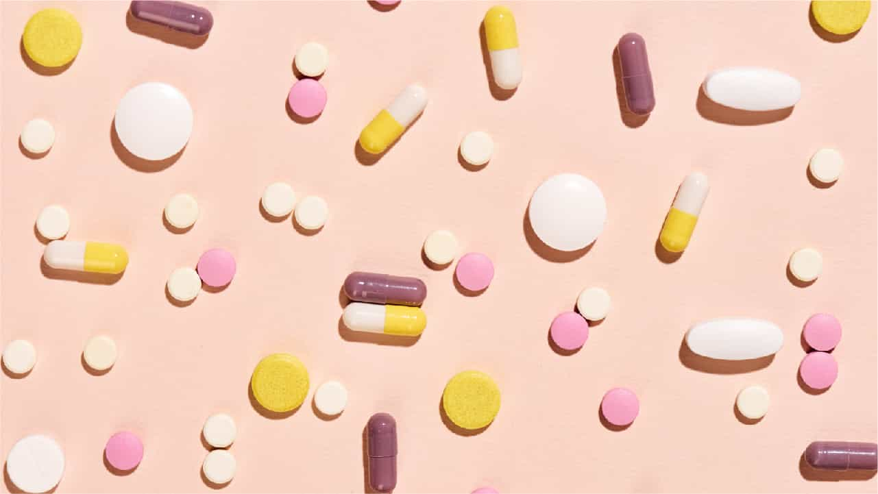 Colorful pills against a pink background depicting the various forms of 'magnesium supplementation