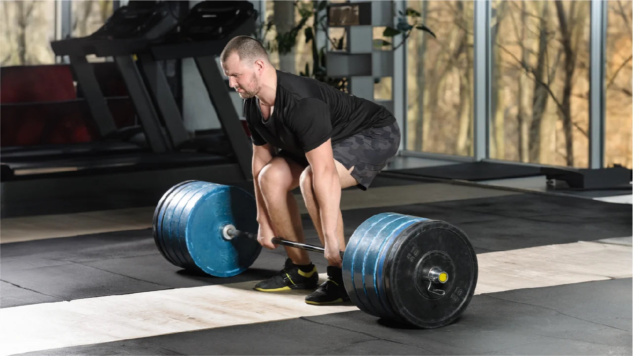 Man in a gym performing deadlift, one of the best exercises for thicker back.