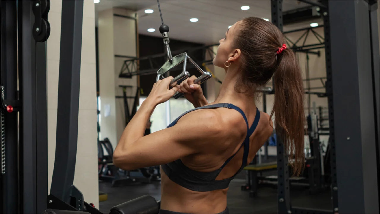 A woman with a well-muscled back performing neutral grip pulldown exercise in the gym.