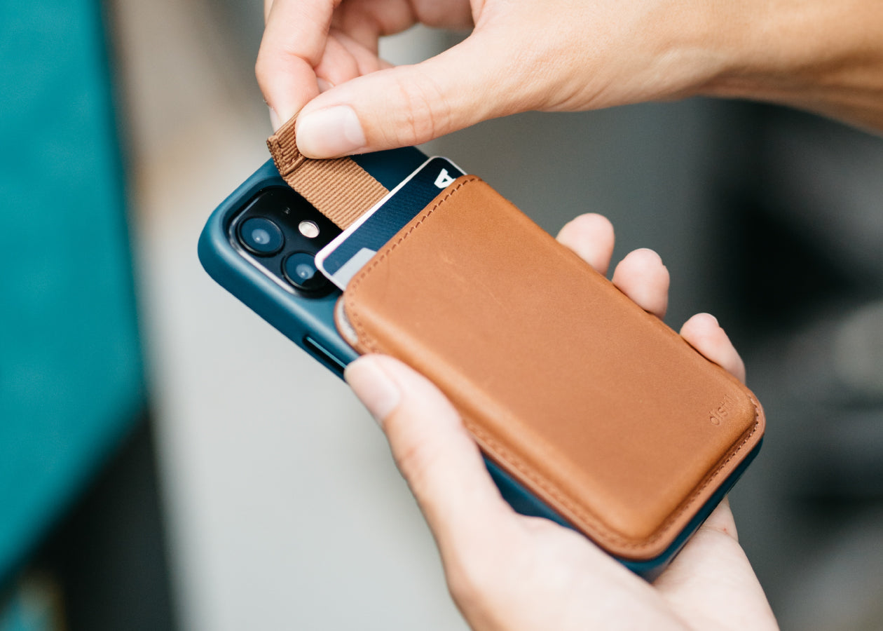 Wally Junior with MagSafe in brown leather shown in use on the back of an Apple iPhone