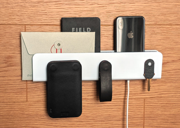 Distil Union ModStation hangs on a wall with an iPhone and charging cable to help solve cord clutter